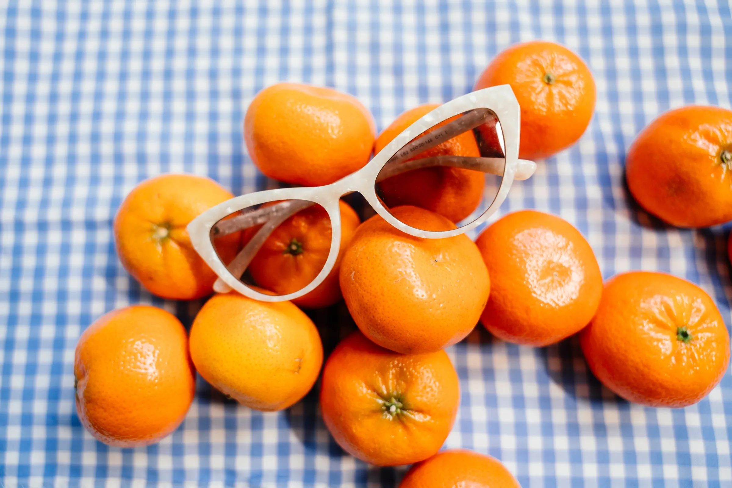 Oranges and sunglasses on blue gingham