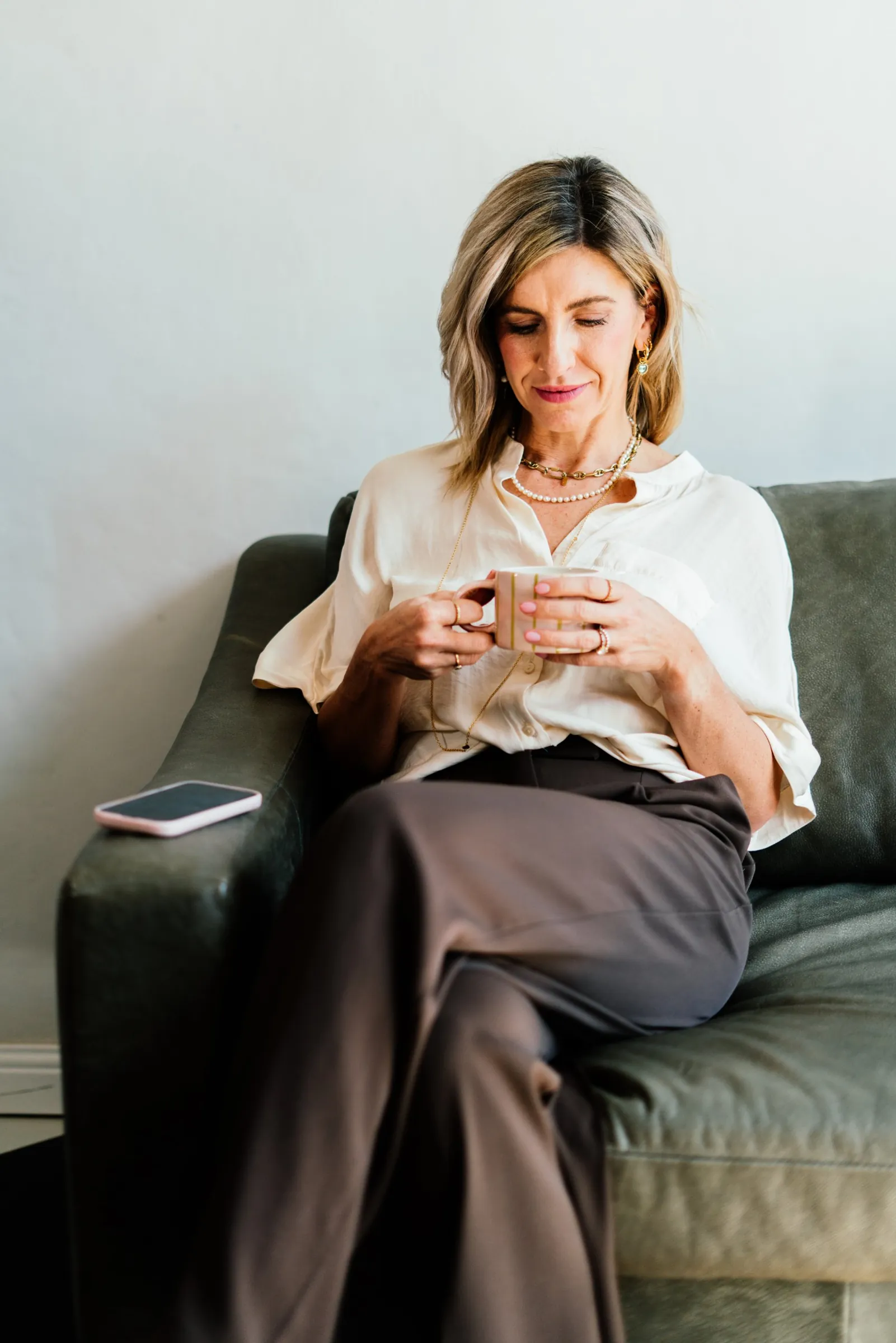 Jeanine on a sofa with a cup of coffee