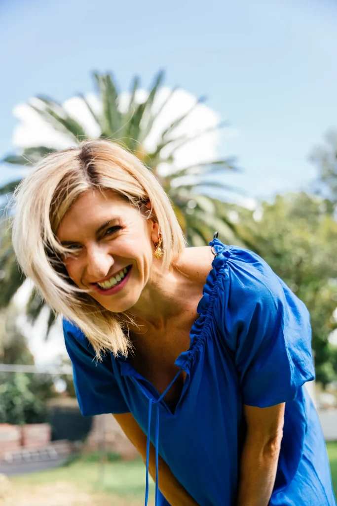 Jeanine laughing under a palm tree
