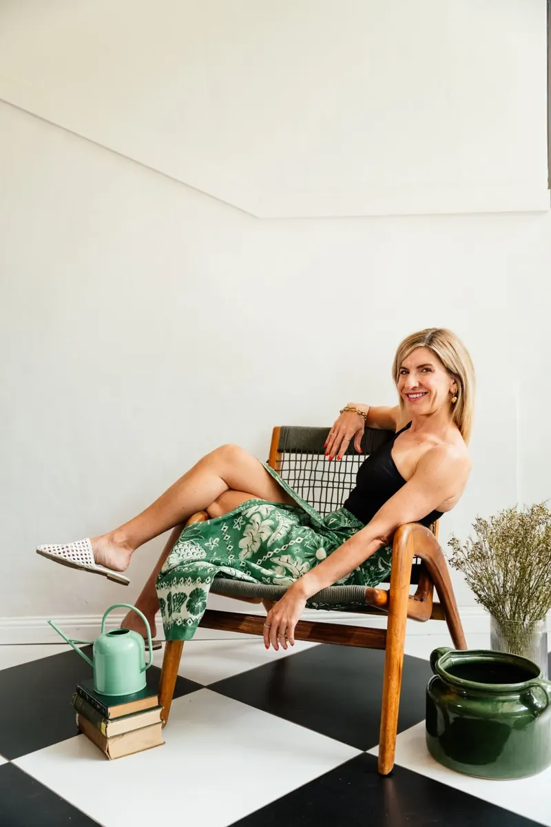 Jeanine on a bench in a green printed skirt