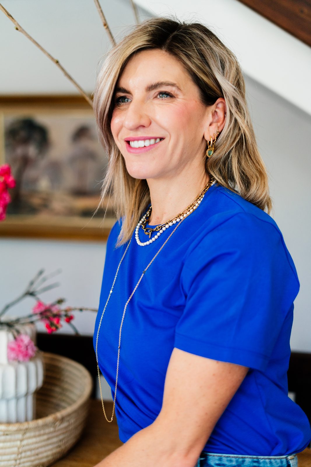 Jeanine in a blue tee, laughing, at home