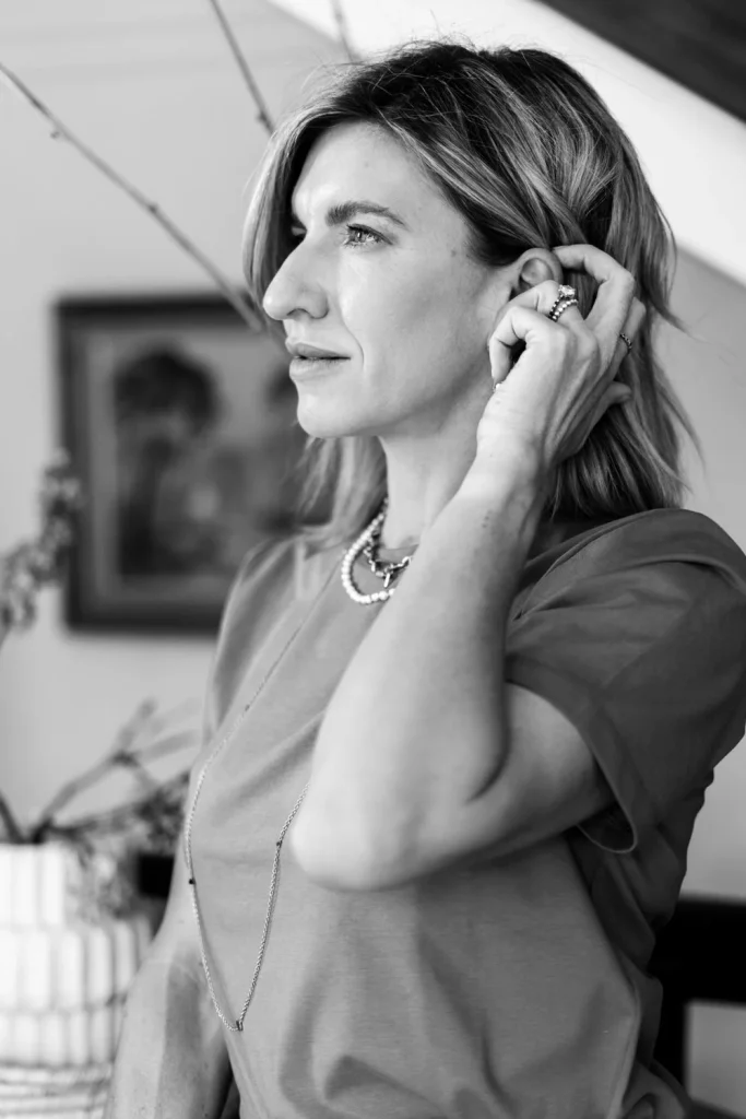 Black and white portrait of Jeanine in profile, one hand at her ear